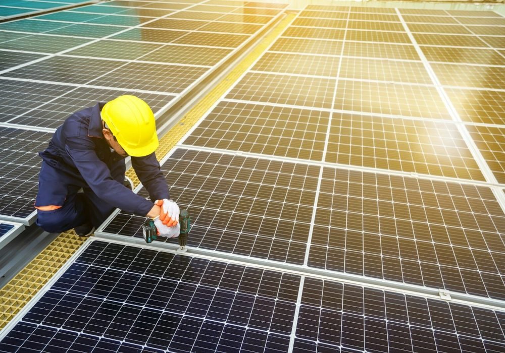 A man in a hardhat working on a solar panel